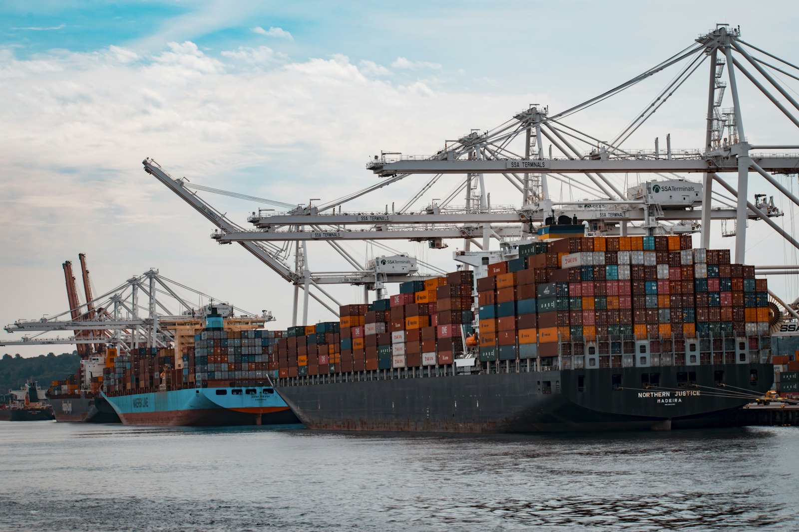 Container vessel alongside a port terminal under gantry cranes